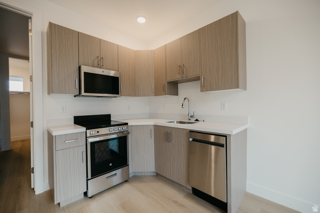 2759 Becco Trail, Unit 16 St. George, UT 84770 - Photo 41 of 42 Kitchen with appliances with stainless steel finishes, modern cabinets, light wood-type flooring, and light stone countertops