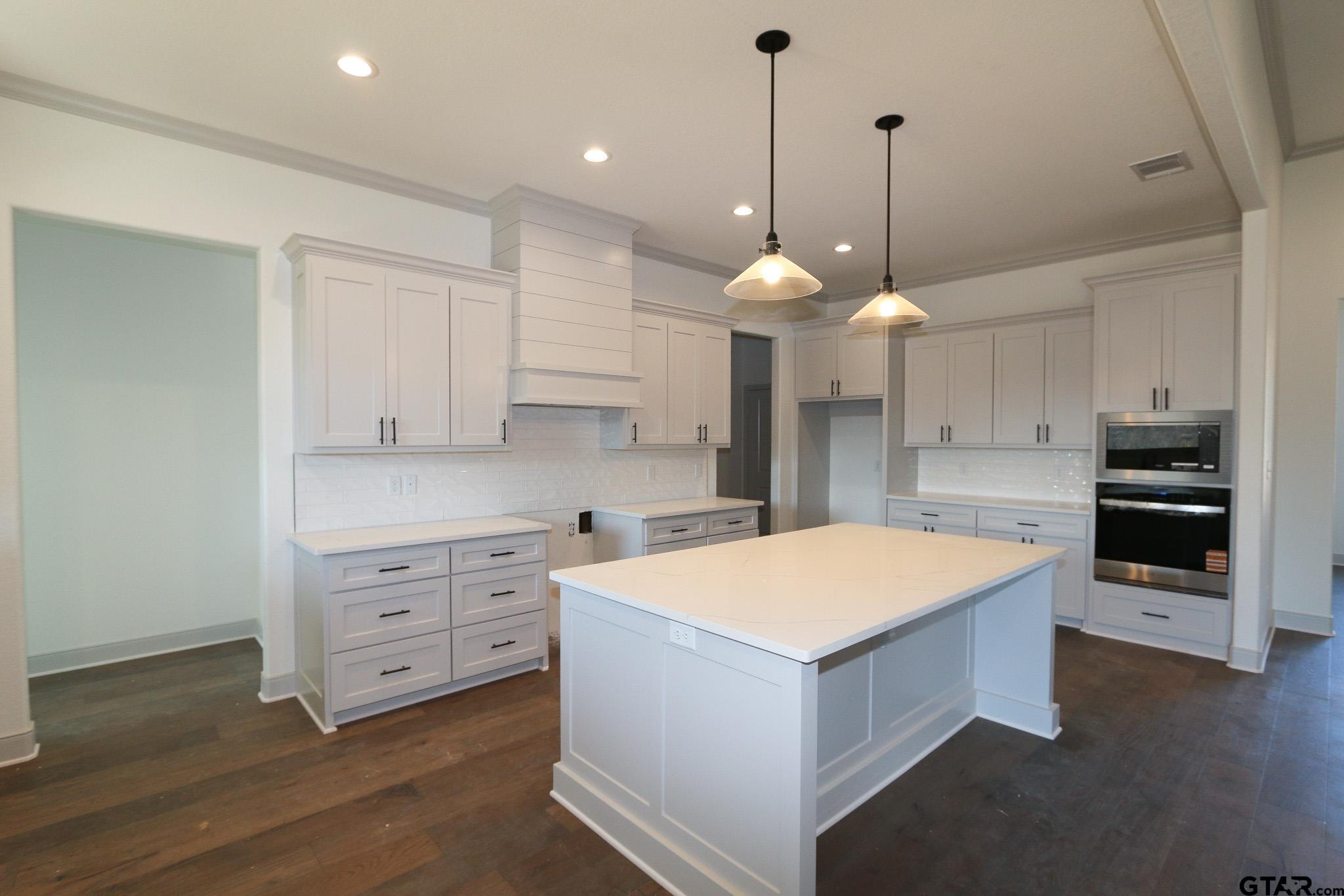 16527 Cooper Way Flint, TX 75762 - Photo 15 of 33 a large kitchen with kitchen island a stove a sink a center island and wooden floor