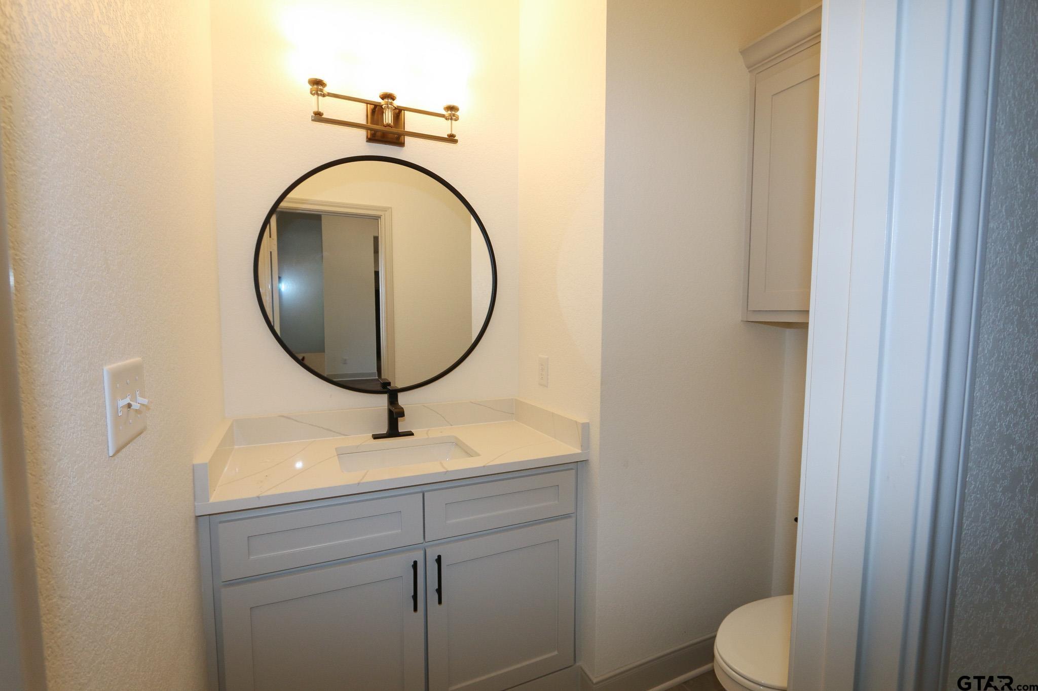 16527 Cooper Way Flint, TX 75762 - Photo 29 of 33 a bathroom with a toilet a sink and mirror