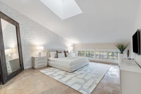 a bedroom with a large bed and a flat tv screen on dresser