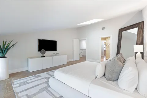 a bedroom with a flat screen tv and a bed