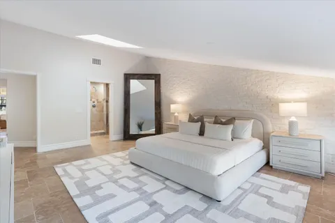 a bedroom with a large bed and a night stand