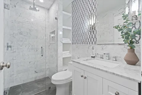 a bathroom with a granite countertop sink a toilet and shower