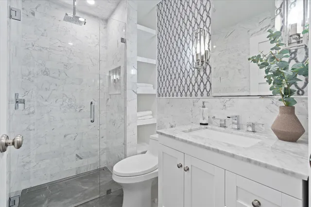 a bathroom with a granite countertop sink a toilet and shower