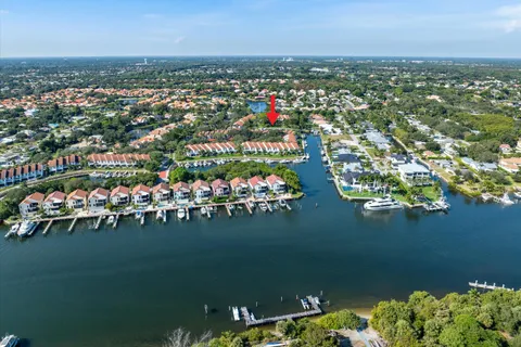 an aerial view of a city with lots of residential buildings ocean and mountain view in back
