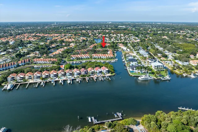an aerial view of a city with lots of residential buildings ocean and mountain view in back