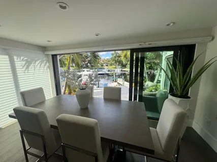 a view of a dining room with furniture large windows and wooden floor