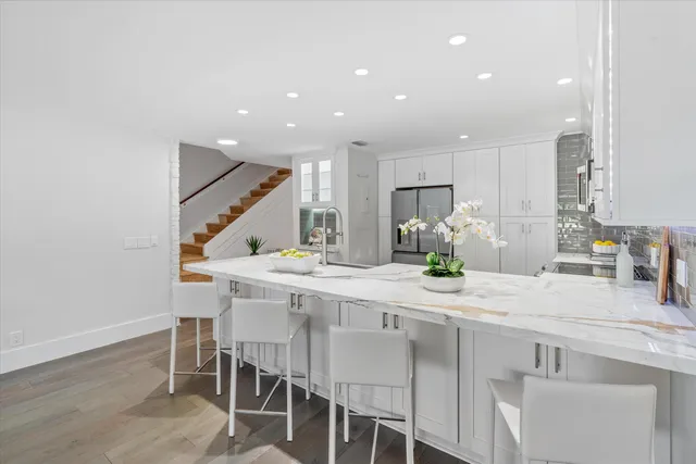 a kitchen with kitchen island granite countertop a table and chairs in it