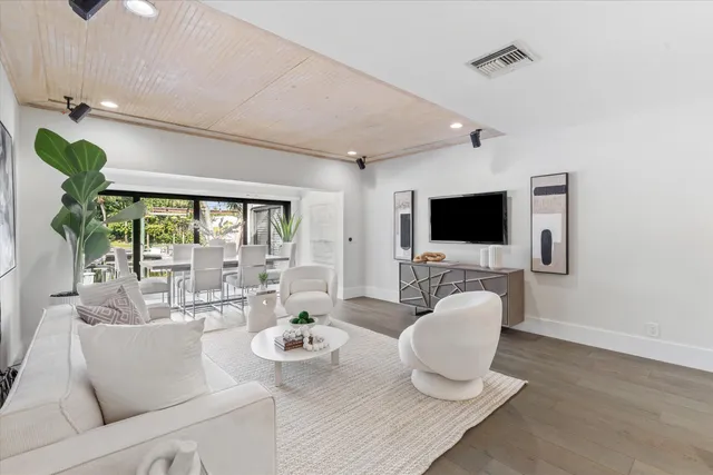 a living room with furniture a flat screen tv and a floor to ceiling window