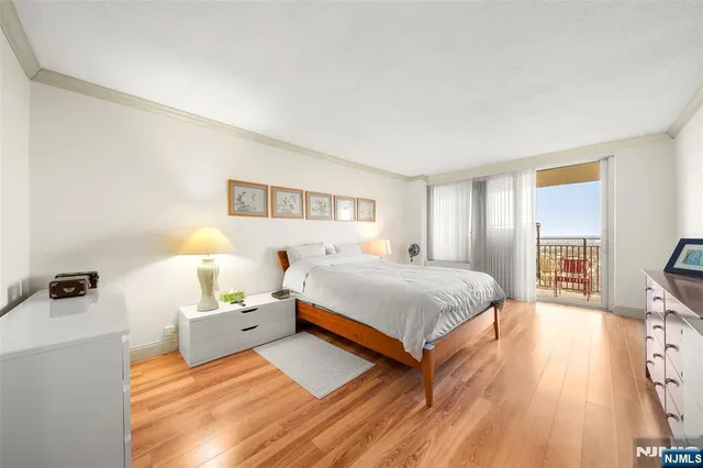 a spacious bedroom with a bed and wooden floor