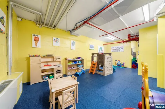 a view of game room with wooden floor and furniture