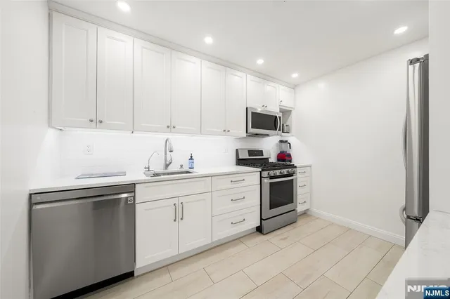 a kitchen with stainless steel appliances granite countertop a sink and cabinets
