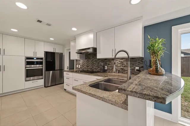 a kitchen with granite countertop a sink and a stove