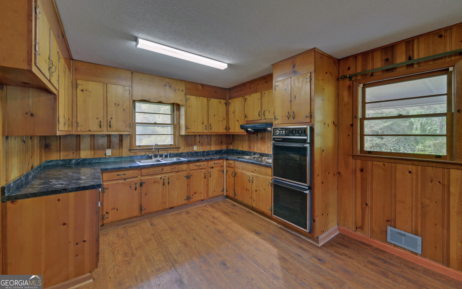 586 Collins Road Toccoa, GA 30577 - Photo 11 of 52 a kitchen with stainless steel appliances granite countertop a refrigerator a sink dishwasher a stove and white countertops with wooden floor