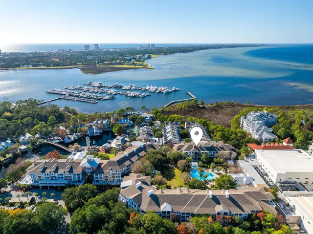 an aerial view of ocean and residential houses with outdoor space
