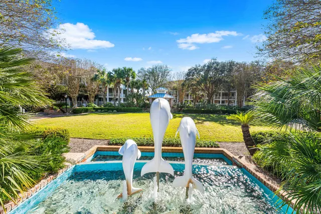 a view of a brick house with large windows and a small yard