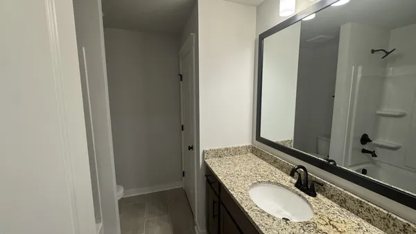 a bathroom with a granite countertop sink and a mirror
