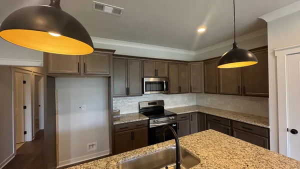 a kitchen with stainless steel appliances granite countertop a stove a refrigerator and a sink