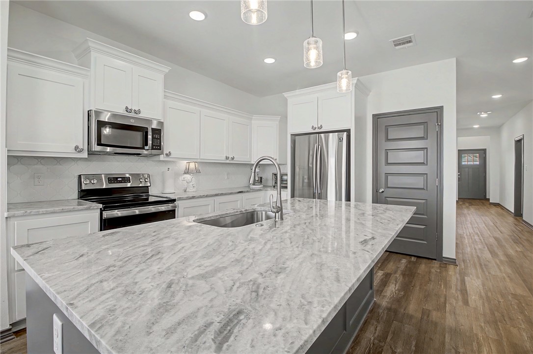 2406 Lightfoot Lane Bryan, TX 77803 - Photo 15 of 38 a kitchen with stainless steel appliances granite countertop a sink refrigerator and microwave