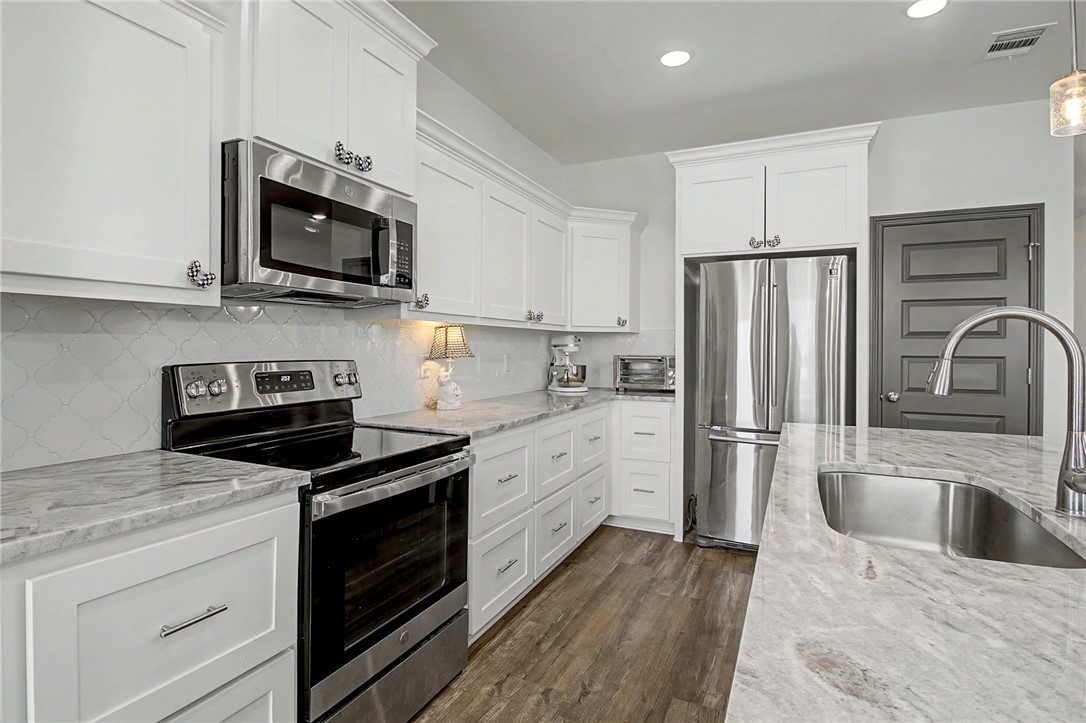 2406 Lightfoot Lane Bryan, TX 77803 - Photo 16 of 38 a kitchen with white cabinets and stainless steel appliances