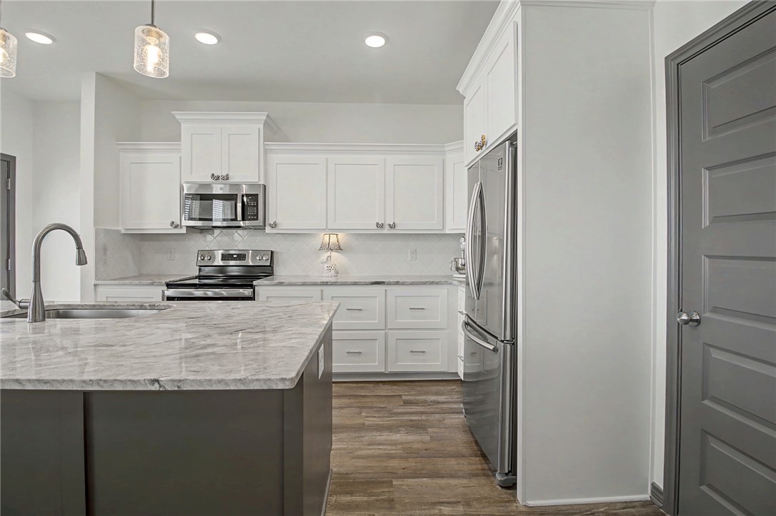 2406 Lightfoot Lane Bryan, TX 77803 - Photo 17 of 38 a kitchen with kitchen island a sink stainless steel appliances and cabinets
