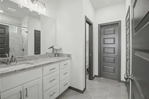 a bathroom with a granite countertop sink a shower and a mirror