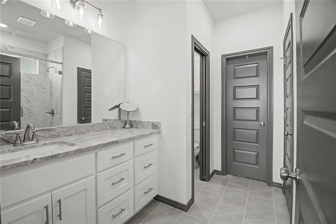 2406 Lightfoot Lane Bryan, TX 77803 - Photo 19 of 38 a bathroom with a granite countertop sink and a mirror