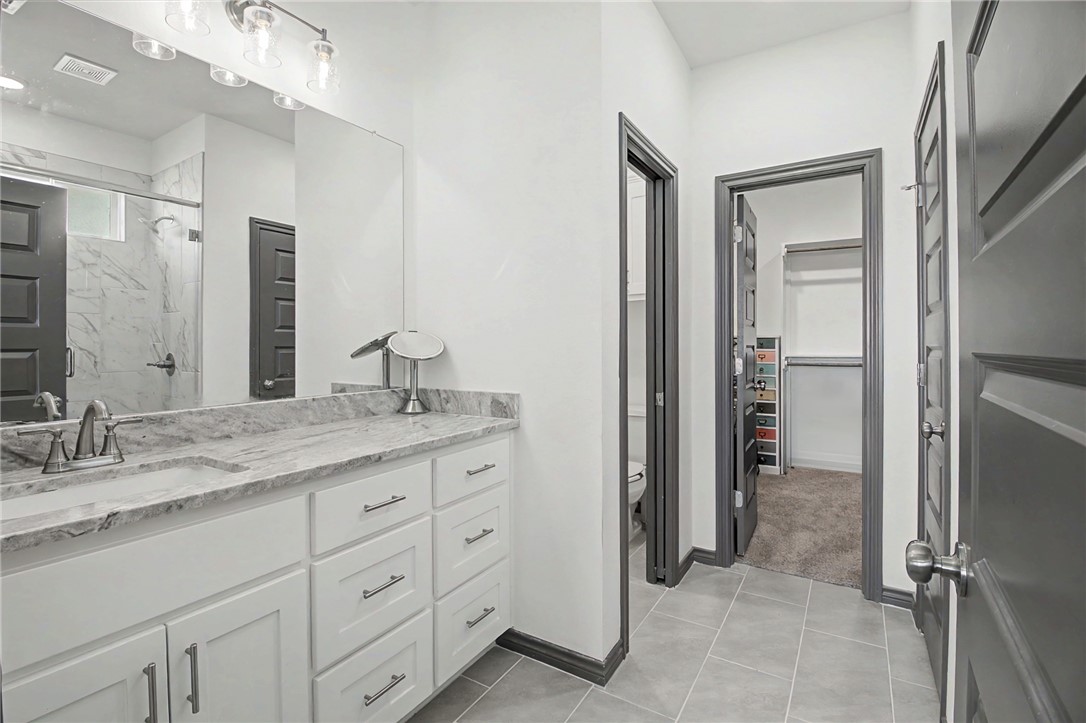 2406 Lightfoot Lane Bryan, TX 77803 - Photo 20 of 38 a bathroom with a granite countertop sink and a mirror