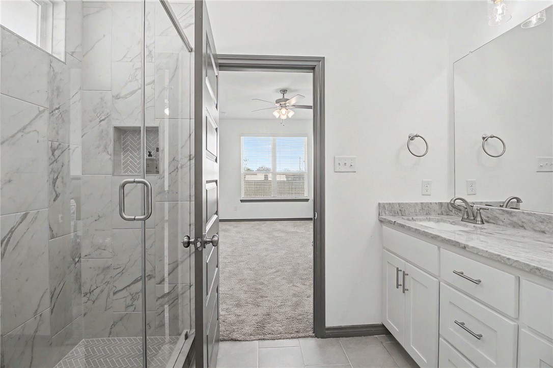 2406 Lightfoot Lane Bryan, TX 77803 - Photo 20 of 38 a bathroom with a granite countertop sink a shower and a mirror