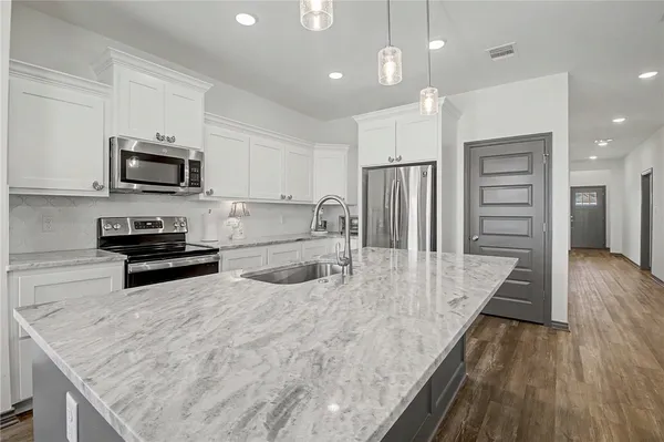 a kitchen with stainless steel appliances granite countertop a refrigerator sink and stove