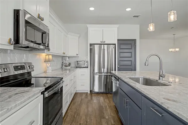 a kitchen with kitchen island a sink stainless steel appliances and cabinets