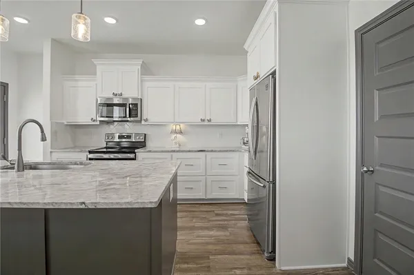 a kitchen with white cabinets and stainless steel appliances