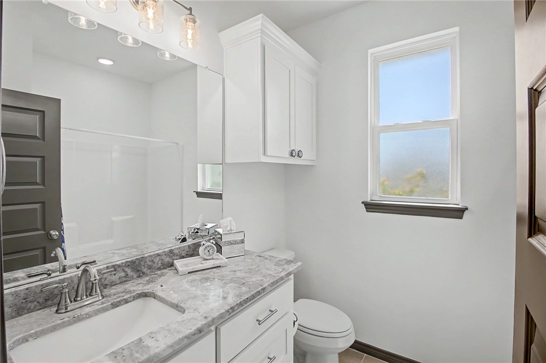2406 Lightfoot Lane Bryan, TX 77803 - Photo 27 of 38 a bathroom with a granite countertop sink a toilet and a mirror