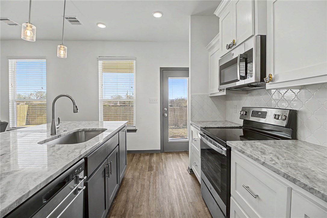 2406 Lightfoot Lane Bryan, TX 77803 - Photo 29 of 38 a kitchen with stainless steel appliances granite countertop a sink a stove and a microwave