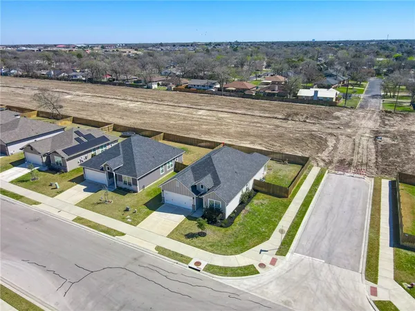 an aerial view of a house with a yard and lake view