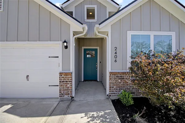 a view of a hallway with wooden floor and a bathroom