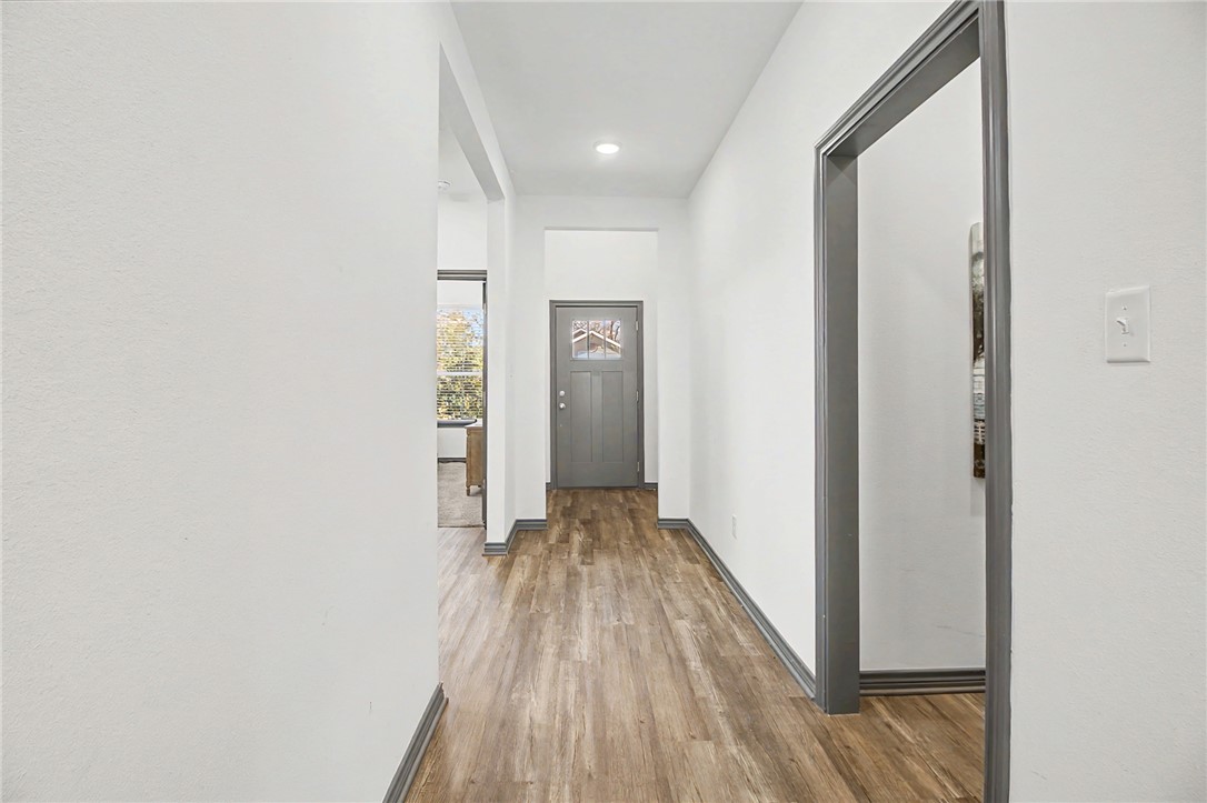 2406 Lightfoot Lane Bryan, TX 77803 - Photo 8 of 38 a view of a hallway with wooden floor and a bathroom