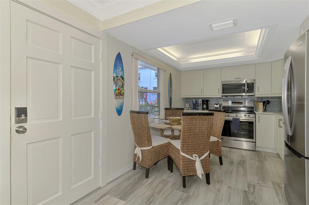 446 Canal Road, Unit 5 Sarasota, FL 34242 - Photo 8 of 64 a kitchen with stainless steel appliances granite countertop a refrigerator a stove a sink dishwasher and white cabinets with wooden floor