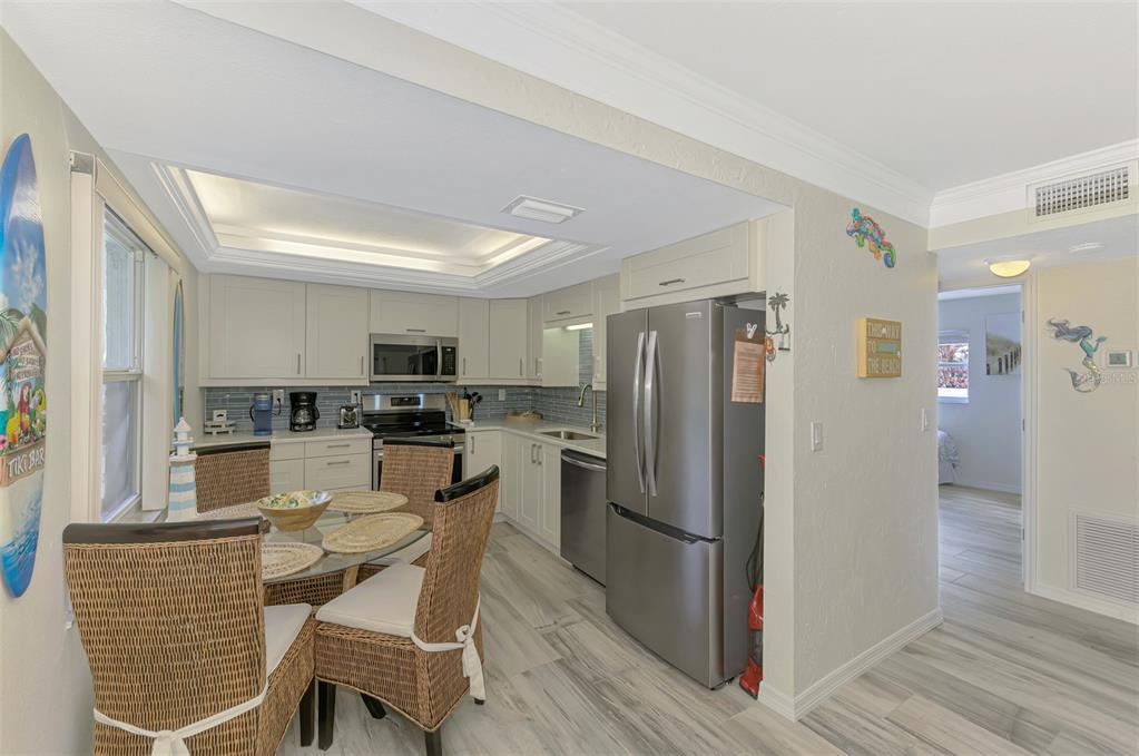 446 Canal Road, Unit 5 Sarasota, FL 34242 - Photo 9 of 64 a kitchen with stainless steel appliances wooden floor and chair