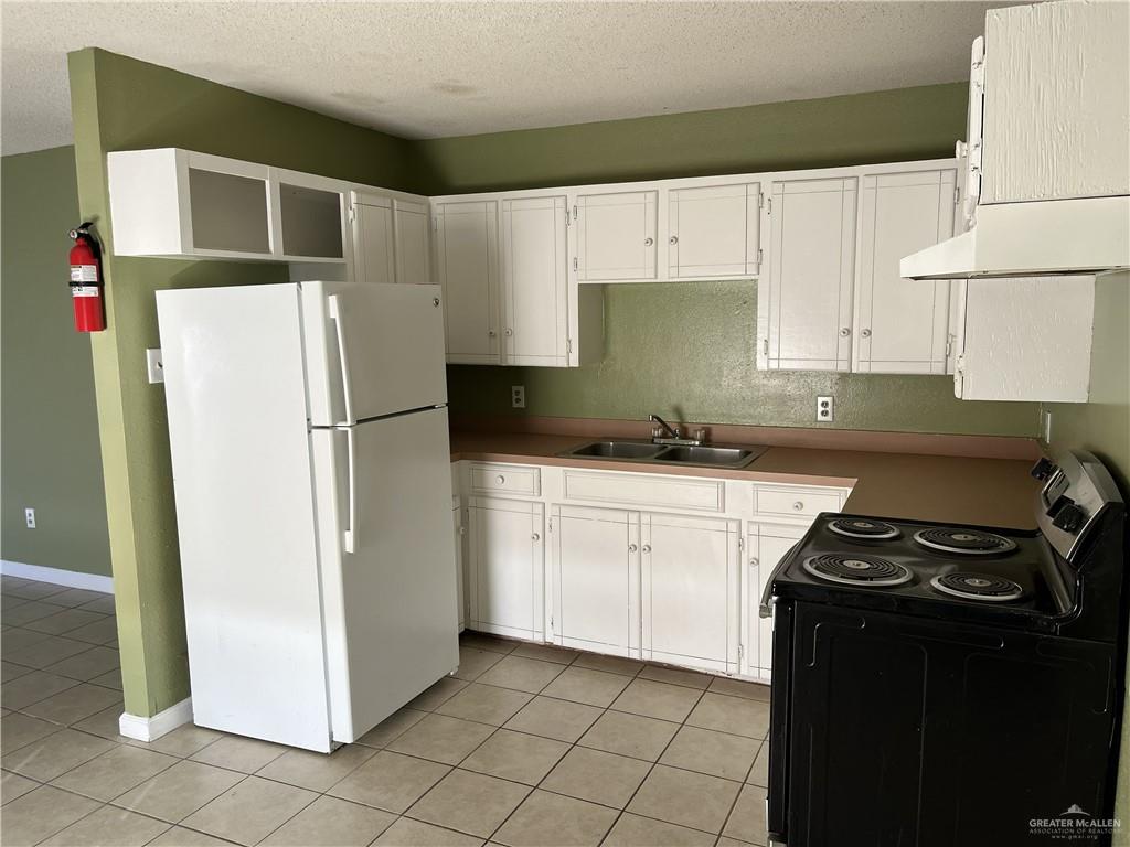 19310 North Mile 6 West Edcouch, TX 78538 - Photo 10 of 15 a kitchen with a refrigerator and a stove top oven