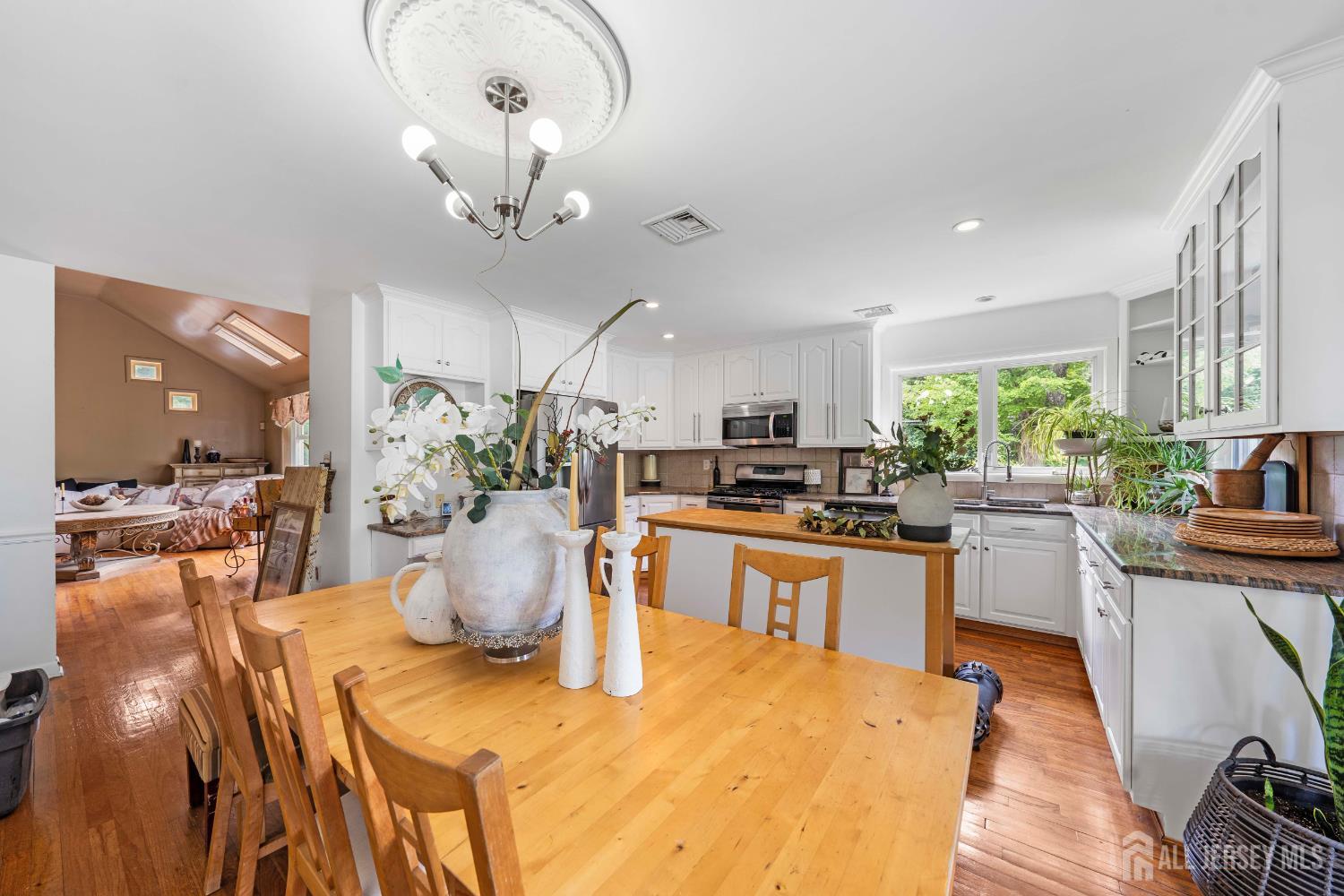 101 Weston Road Somerset, NJ 08873 - Photo 11 of 32 a kitchen with stainless steel appliances granite countertop a stove a sink dishwasher a dining table and chairs with wooden floor