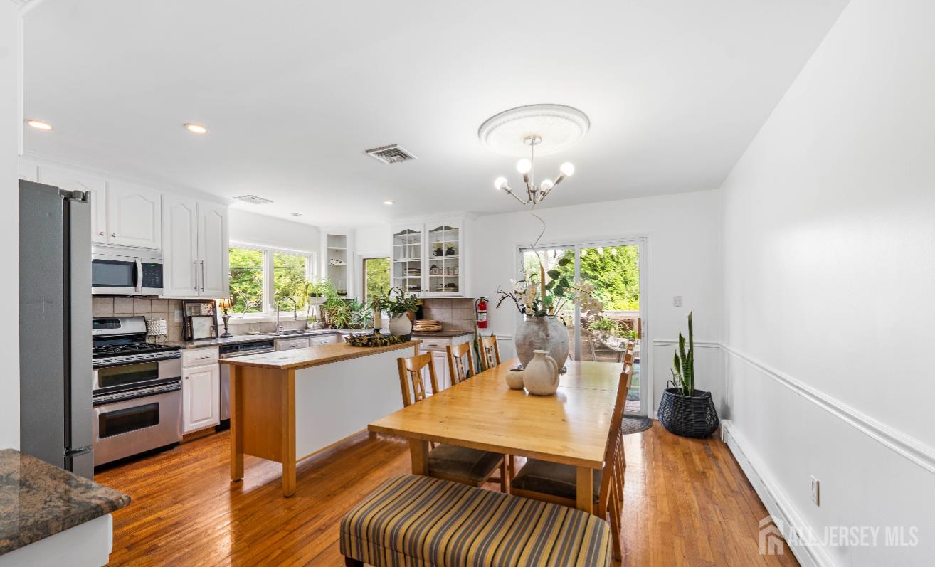 101 Weston Road Somerset, NJ 08873 - Photo 13 of 32 a very nice looking dining room with kitchen island stainless steel appliances furniture a large window and wooden floor