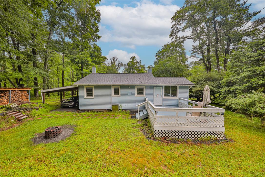 5599 Minks Pond Road Bushkill, PA 18324 - Photo 61 of 64 A tranquil woodland retreat, this home offers a deck for outdoor enjoyment and a practical carport.
