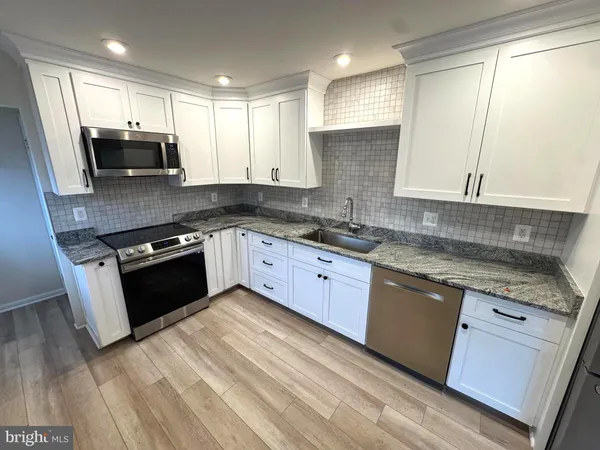 a kitchen with stainless steel appliances granite countertop a stove a sink and a granite counter tops