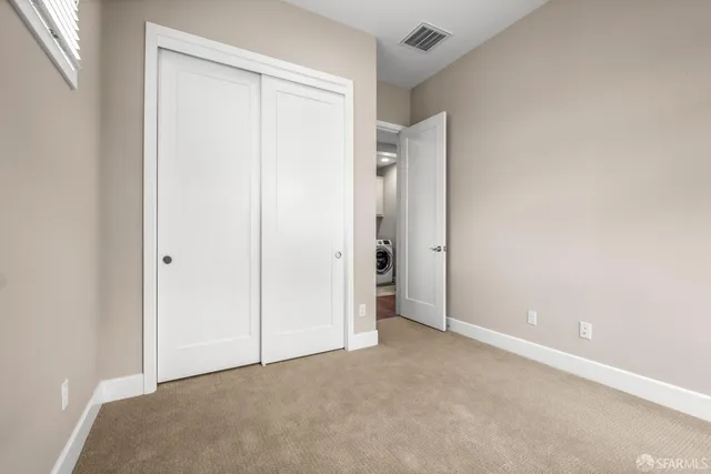a view of a hallway with wooden floor and a living room