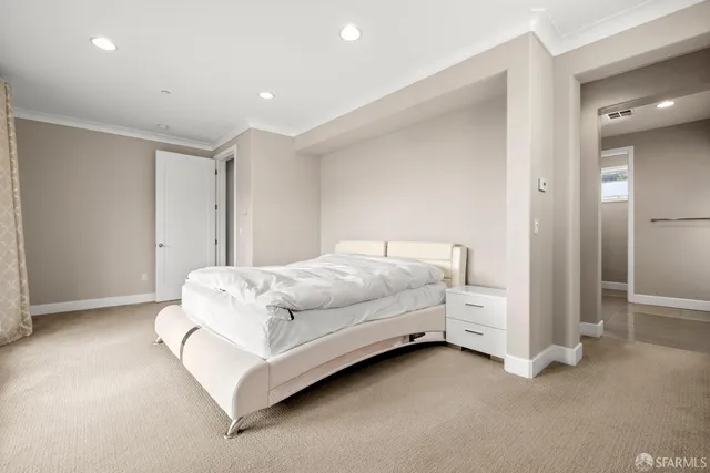 a spacious bedroom with a bed and a large window