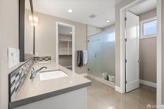 a bathroom with a granite countertop sink and a mirror