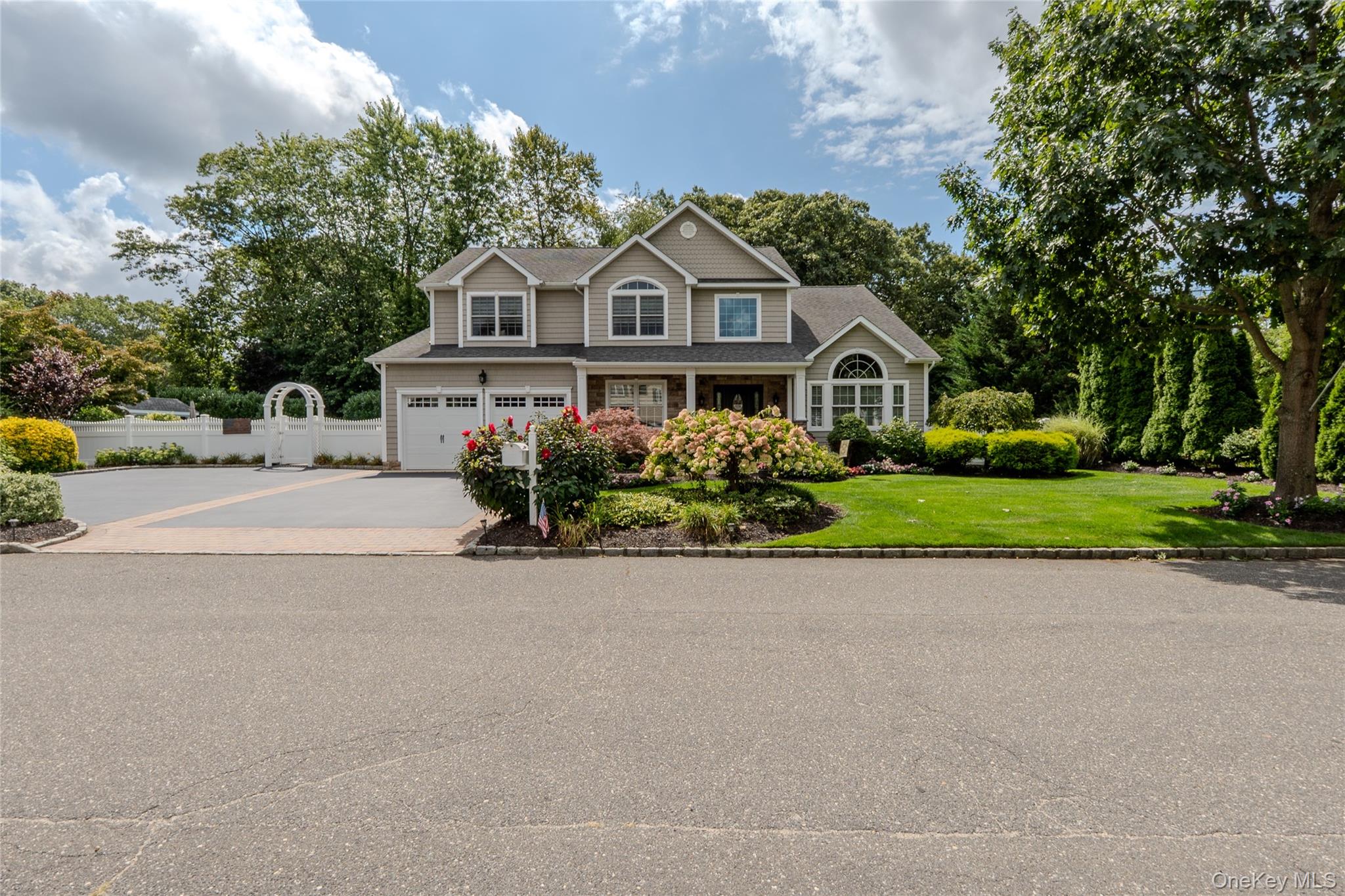 View of front facade with concrete driveway, a garage, and roof with shingles