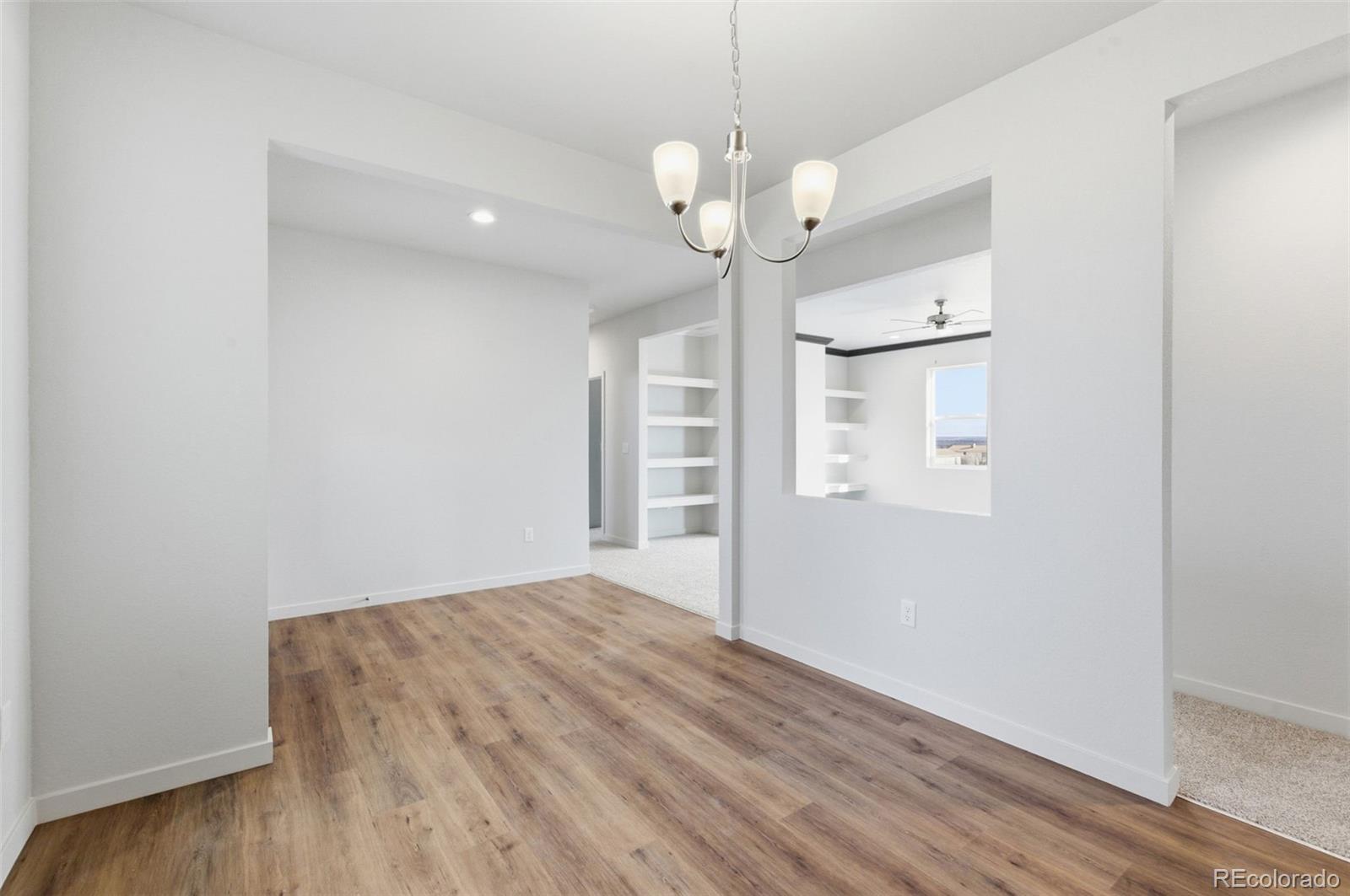 24515 Big Springs Road Peyton, CO 80831 - Photo 14 of 30 an empty room with wooden floor and windows