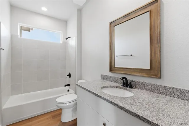 a bathroom with a granite countertop sink toilet and shower